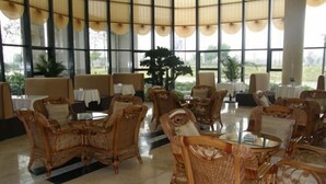 A spacious indoor area with wicker furniture and large windows. - Qingyuan Hotel University of Anhui (Hefei)