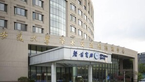 A building with a sign that reads "安吉大学学术交流与合作中心" and "安吉大学" in gold letters on a white background. - Qingyuan Hotel University of Anhui (Hefei)