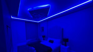 A bedroom with a bed, bedside tables, and a nightstand. - 1 Bed Flat - Sleeps 2 - Hot Tub - Parking - Wifi (Bradford)