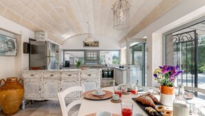 A spacious kitchen with a large island, modern appliances, and a view of the outdoors. - Pigreco 6+2, Emma Villas (Ostuni)