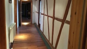 Un couloir doté d’un plancher en bois et d’un décor mural de style japonais traditionnel.