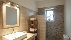 Een moderne badkamer met een grote spiegel, een wastafel, toilet en een douchehoek.