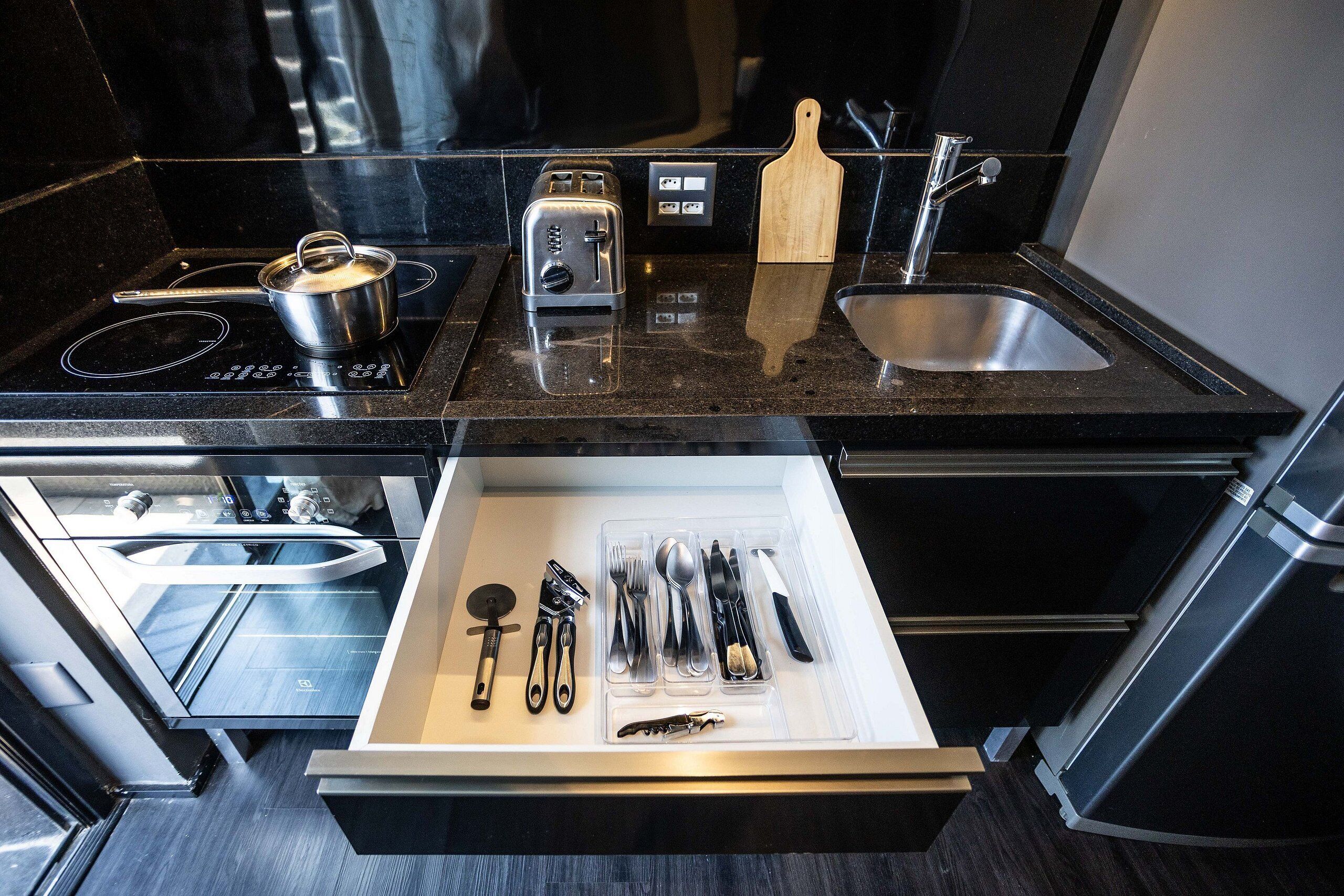 A modern kitchen with a built-in toaster, a cutting board, and a stainless steel sink.
