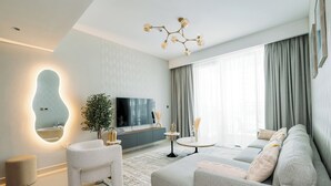 Un salon moderne avec un canapé, une table basse et un téléviseur.