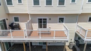 Un bâtiment à deux étages doté d’une terrasse couverte et d’un petit espace patio.