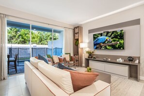 Ein modernes Wohnzimmer mit einer Couch, einem Fernseher und einem Papagei auf einem Ast.