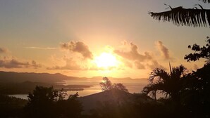 A sunset over a body of water with mountains in the background. - A LOU, A haven of peace with its private jacuzzi for nature lovers ! (Le Diamant)