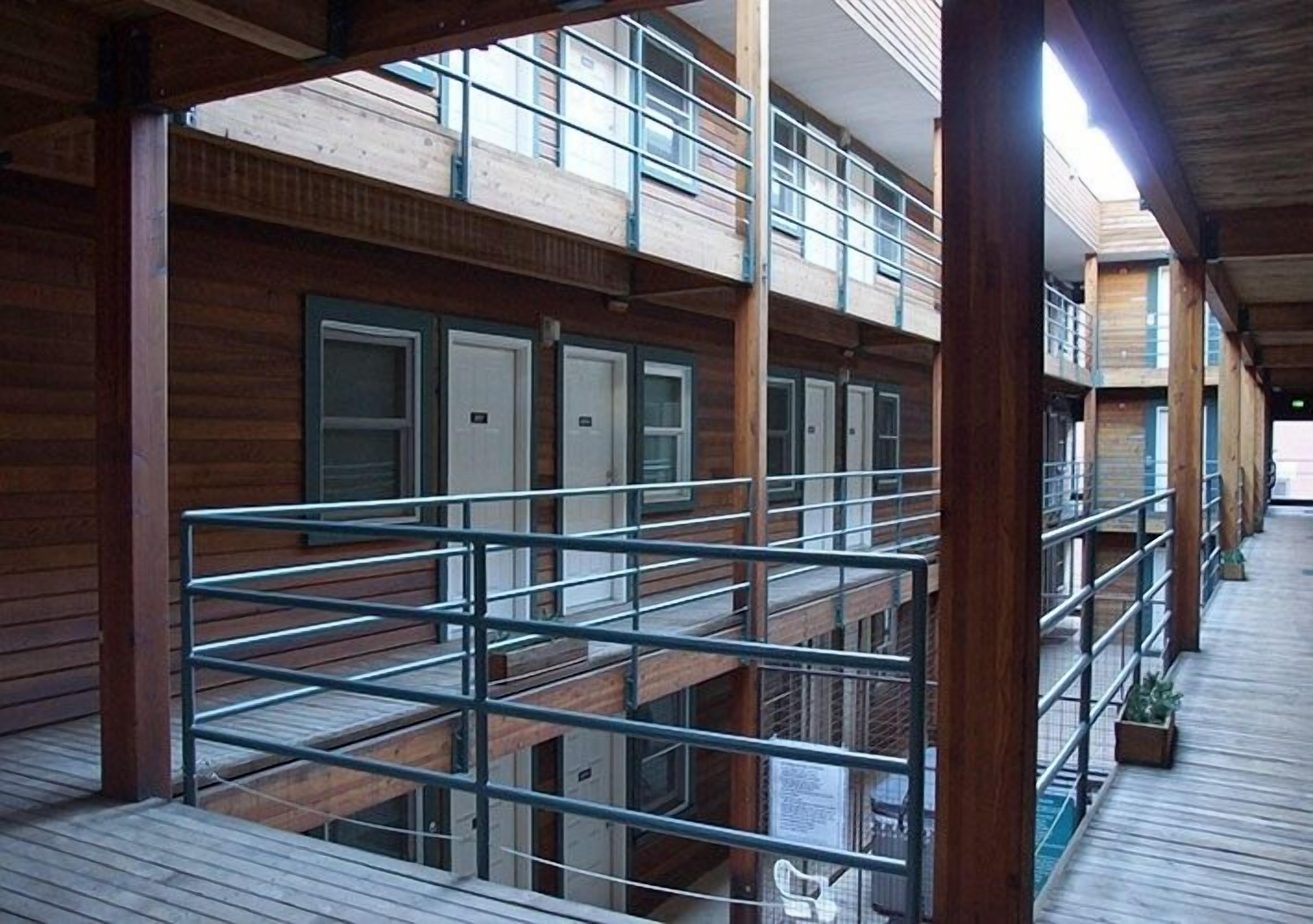 A multi-level wooden building with balconies, railings, and a wooden deck.