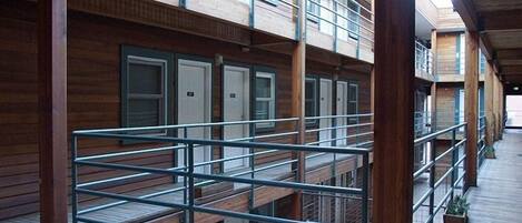 A multi-level wooden building with balconies, railings, and a wooden deck.