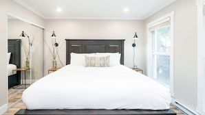 A modern bedroom with a large bed, bedside lamps, a mirror, and a window. - Perfect Location! King Bed, Full Kitchen, Walk To Gondola 2 Bedroom Condo by RedAwning (Telluride)
