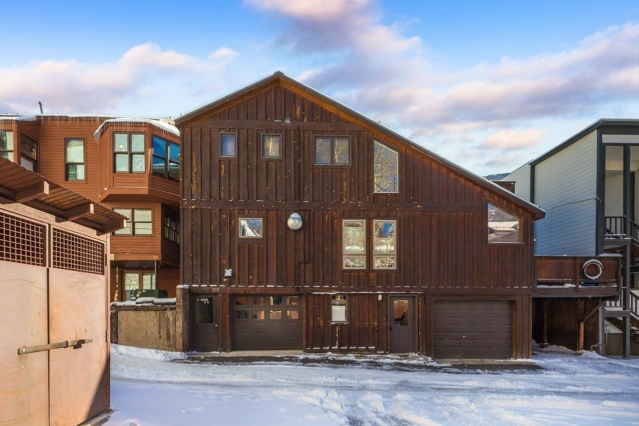 A two-story wooden building with multiple windows and a garage.