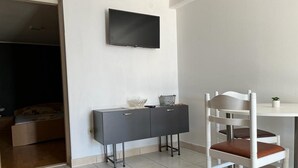 A room with a bed, a desk, a chair, and a TV mounted on the wall. - Apartments Leut (Omis)