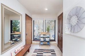 A hallway with a mirror, a bench, a shelf with books, and a door leading to a room. - Hidden Gem, 4 Min To Lift 7 Garage, Hot Tub, Lux Kitchen, Big + Bright 4 Bedroom Condo by RedAwning (Telluride)