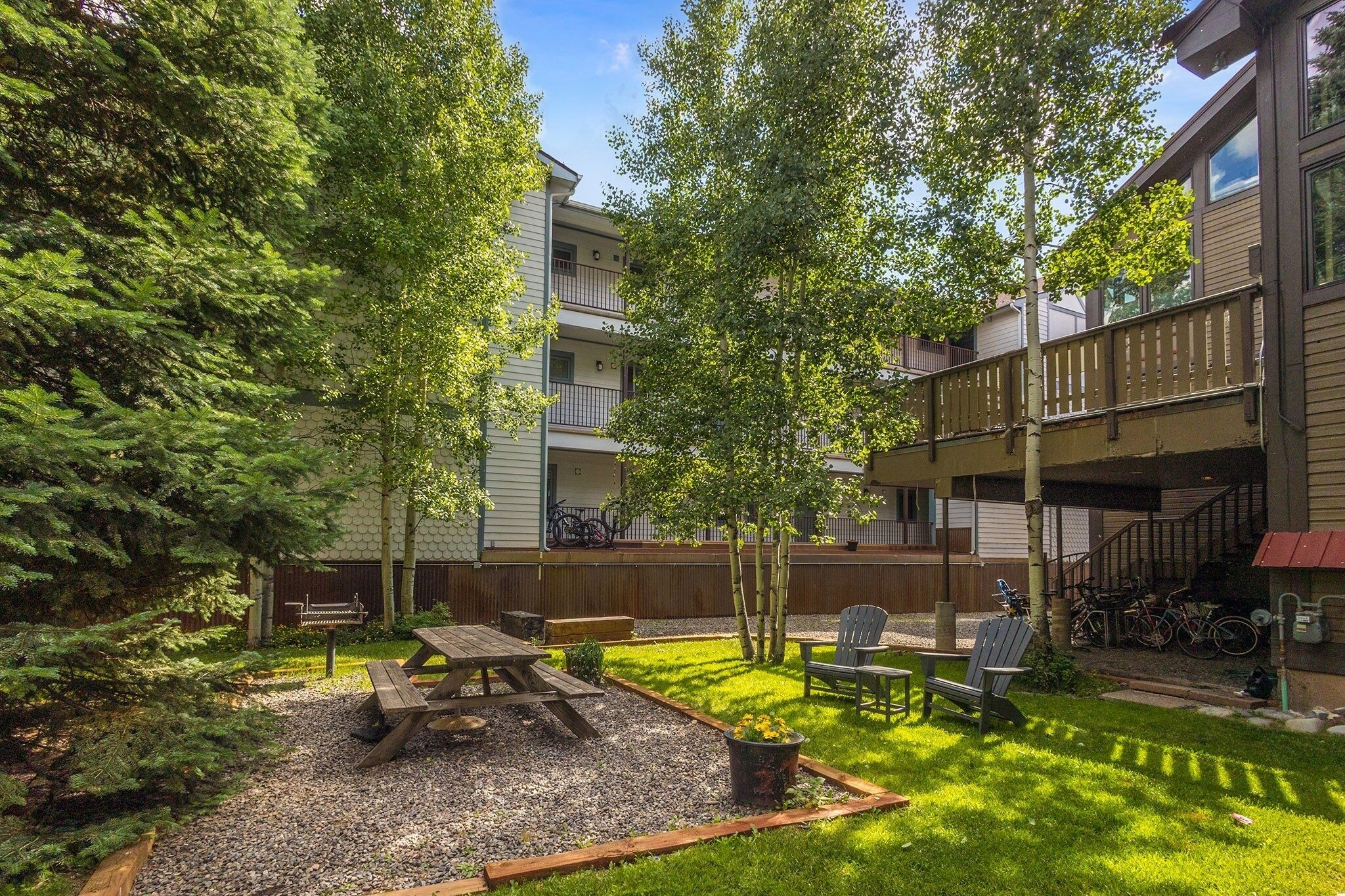 A courtyard with a picnic table, chairs, and bicycles.