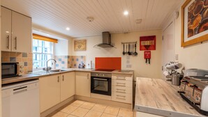 Una cucina moderna con lavastoviglie, forno e macchina del caffè.