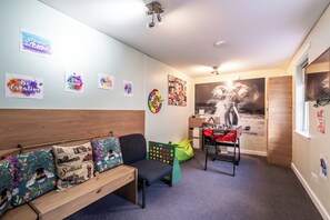 Habitació amb una banca de fusta, un seient de gots verd, un joc de daus i una paret decorada amb pòsters motivacionals.
