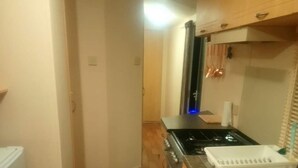 A compact kitchen with a stove, sink, and countertop. - Remarkable Caravan in Abergele Towyn (Abergele)