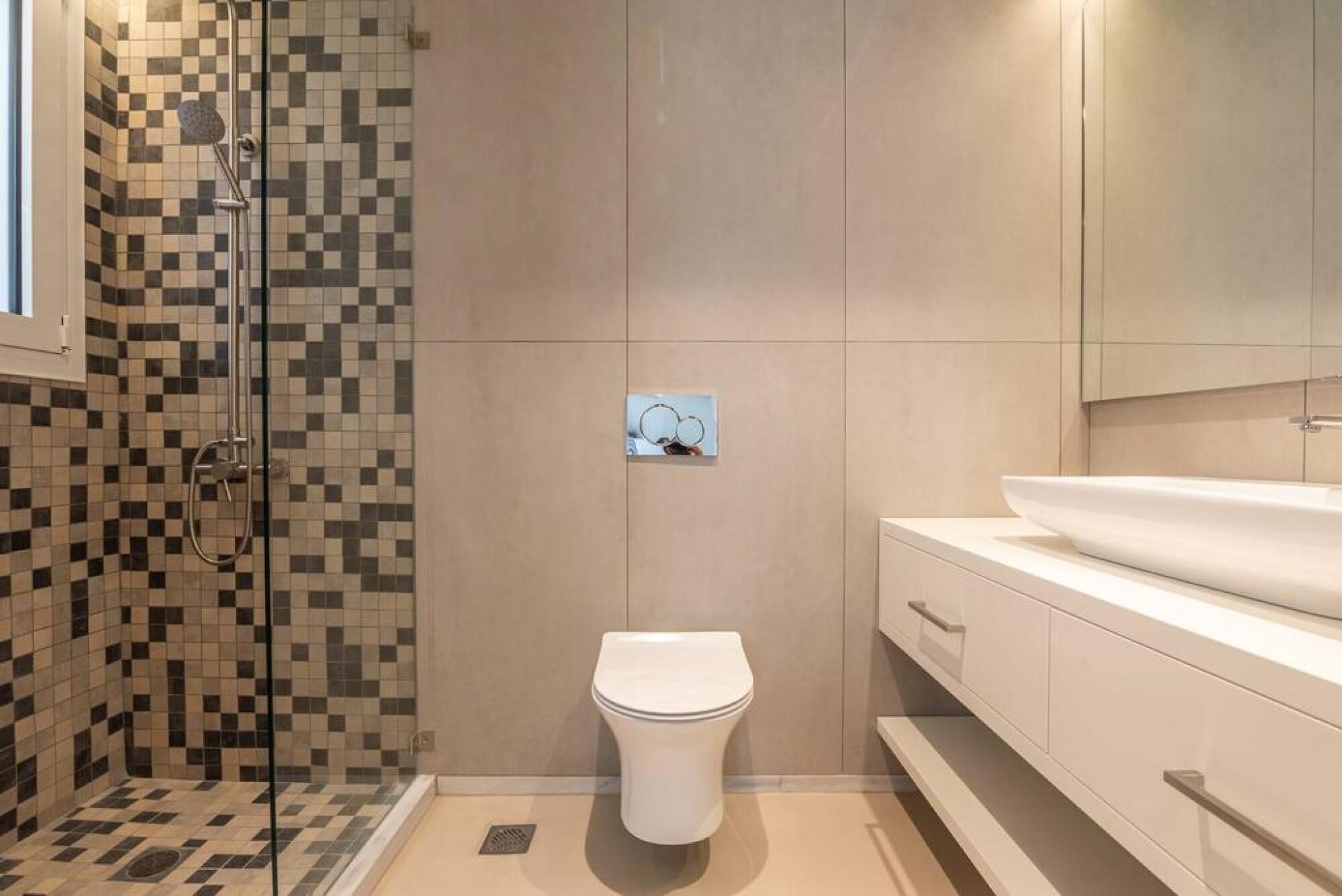 A bathroom with a shower, toilet, and vanity.