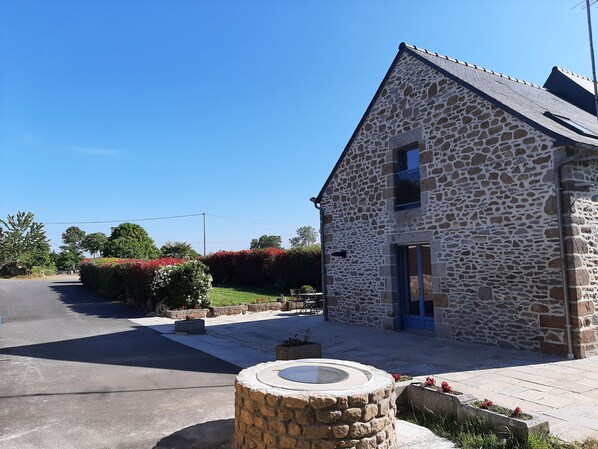 A stone building with a sloped roof, a small window, and a door.