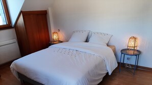 A neatly made bed with white linens, two bedside lamps, and a wooden floor. - The blue house (Saint-Sauveur-des-Landes)