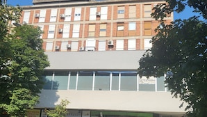 Un edificio de varios pisos con fachada de ladrillo, ventanas amplias y techo plano.
