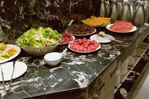 A buffet with various food items including salads, fruits, and desserts. - Tibet Ali Hotel (Gar County)