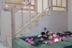 A staircase with a decorative floral arrangement at the bottom. - Tibet Ali Hotel (Gar County)
