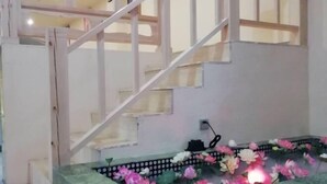 A staircase with a decorative water feature at the bottom, including lotus flowers and a light.