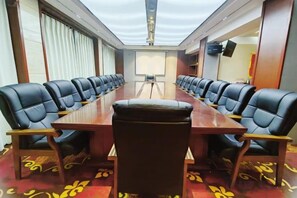 A conference room with a long table and multiple chairs, a projector screen, and a carpeted floor. - Tibet Ali Hotel (Gar County)