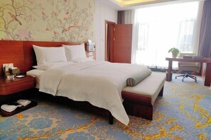 A hotel room with a large bed, a desk, and a chair. - Tibet Ali Hotel (Gar County)