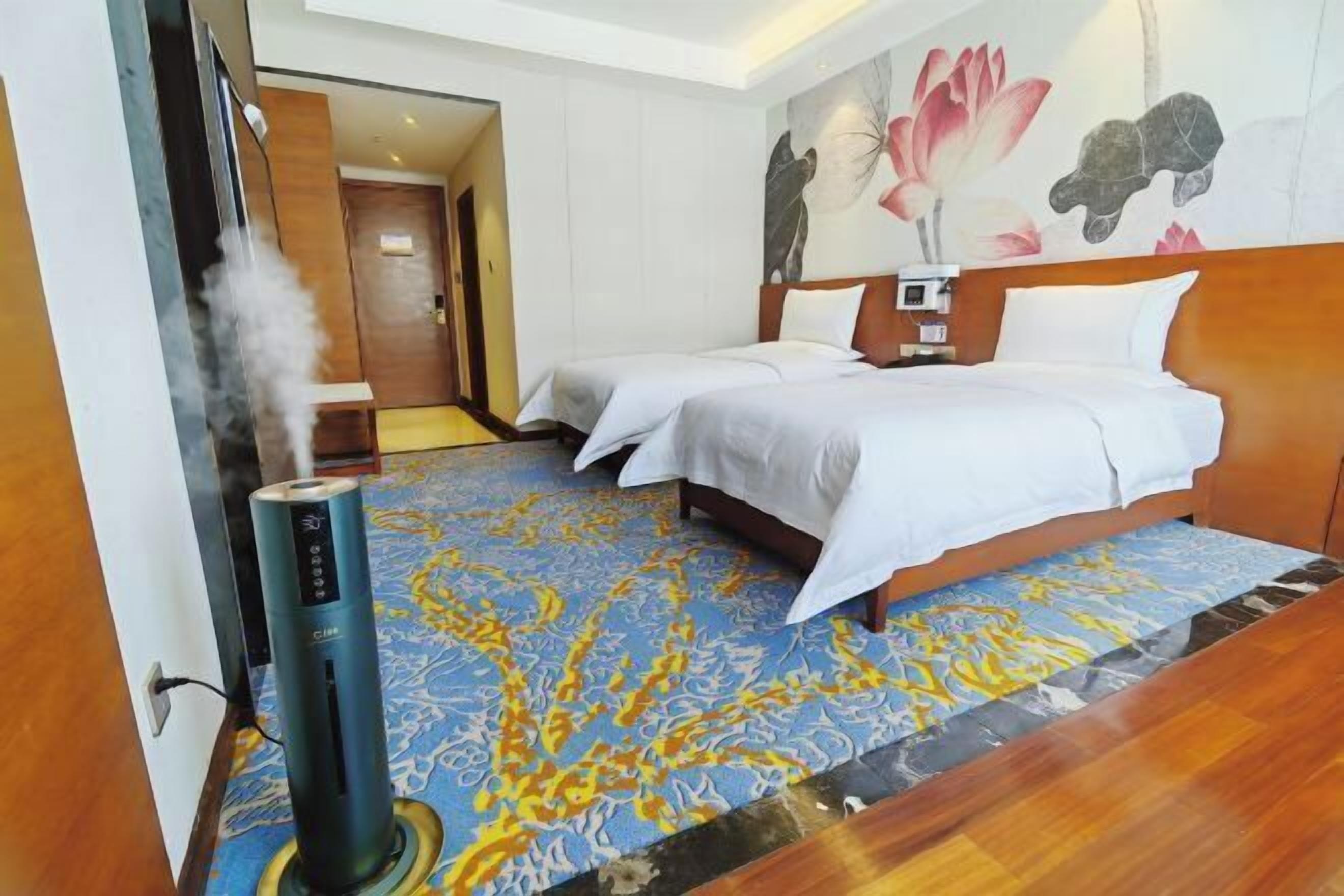 A hotel room with two beds, a massage chair, and a large floral mural on the wall.