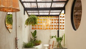 A modern outdoor staircase with concrete steps, surrounded by lush greenery and a bamboo ceiling. - ROSA by DW (San Juan)