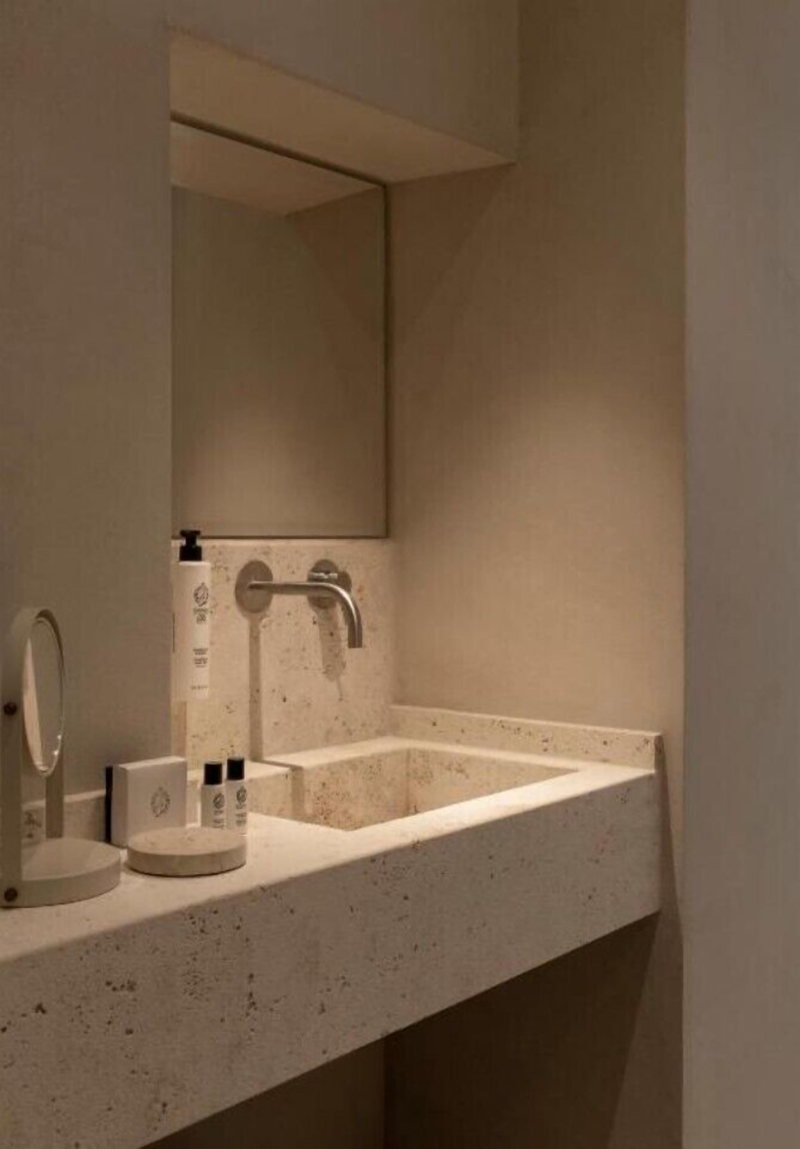 Une salle de bain avec un seul lavabo, un miroir et un robinet.