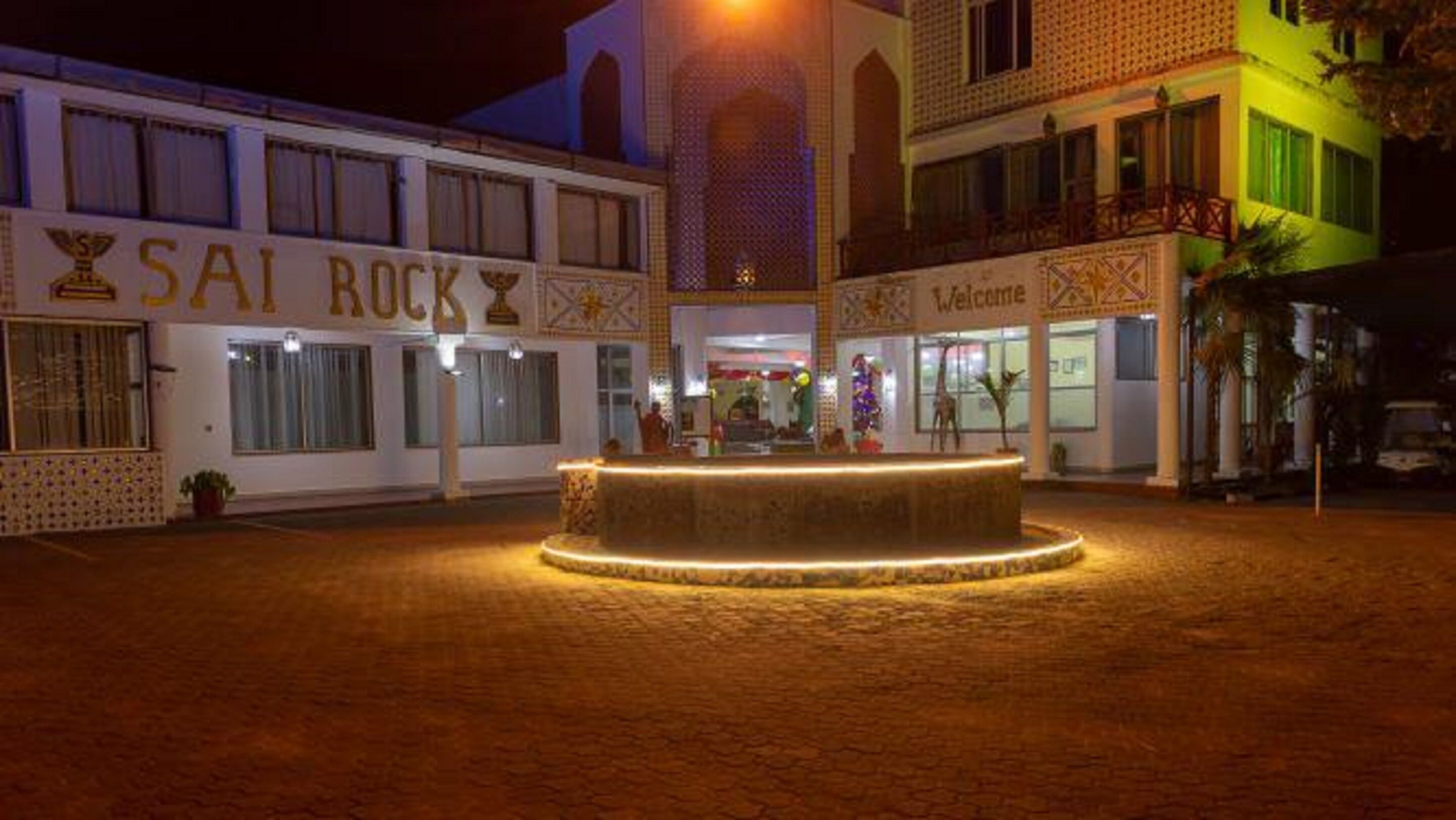 A building with a sign reading "SAI ROCK" and another sign saying "Welcome".
