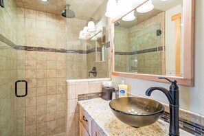 A bathroom with a large mirror, a sink with a bowl basin, a shower with a handheld showerhead, and a towel rack. - Charming Studio W Kitchenette, Hot Tub Near River Condo by RedAwning (Telluride)
