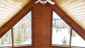 Une pièce aux murs en bois et au plafond en pente.