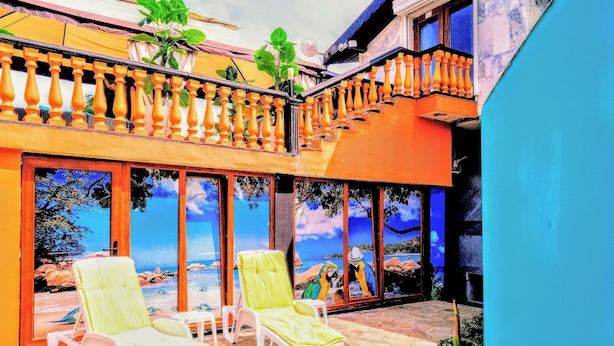 A balcony with two sun loungers, a view of the sea through large windows, and a wooden railing. - Sea Marble Villa Studio (Sozopol)