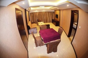 Una habitación de hotel con cama, escritorio, silla y una mesita.