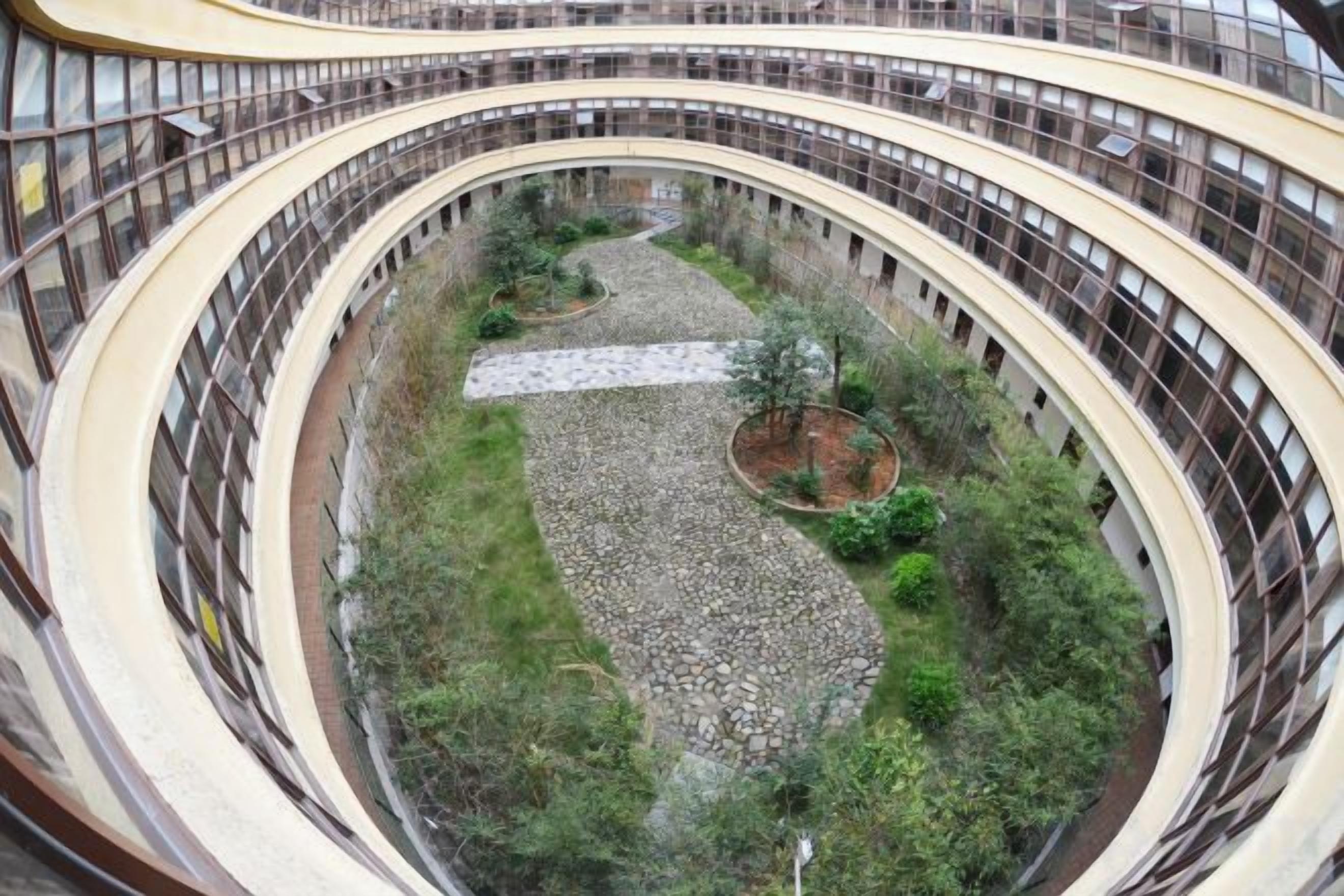 Un atrio de varios niveles con balcones curvos y un jardín central.