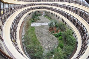 A multi-level atrium with curved balconies and a central garden area.