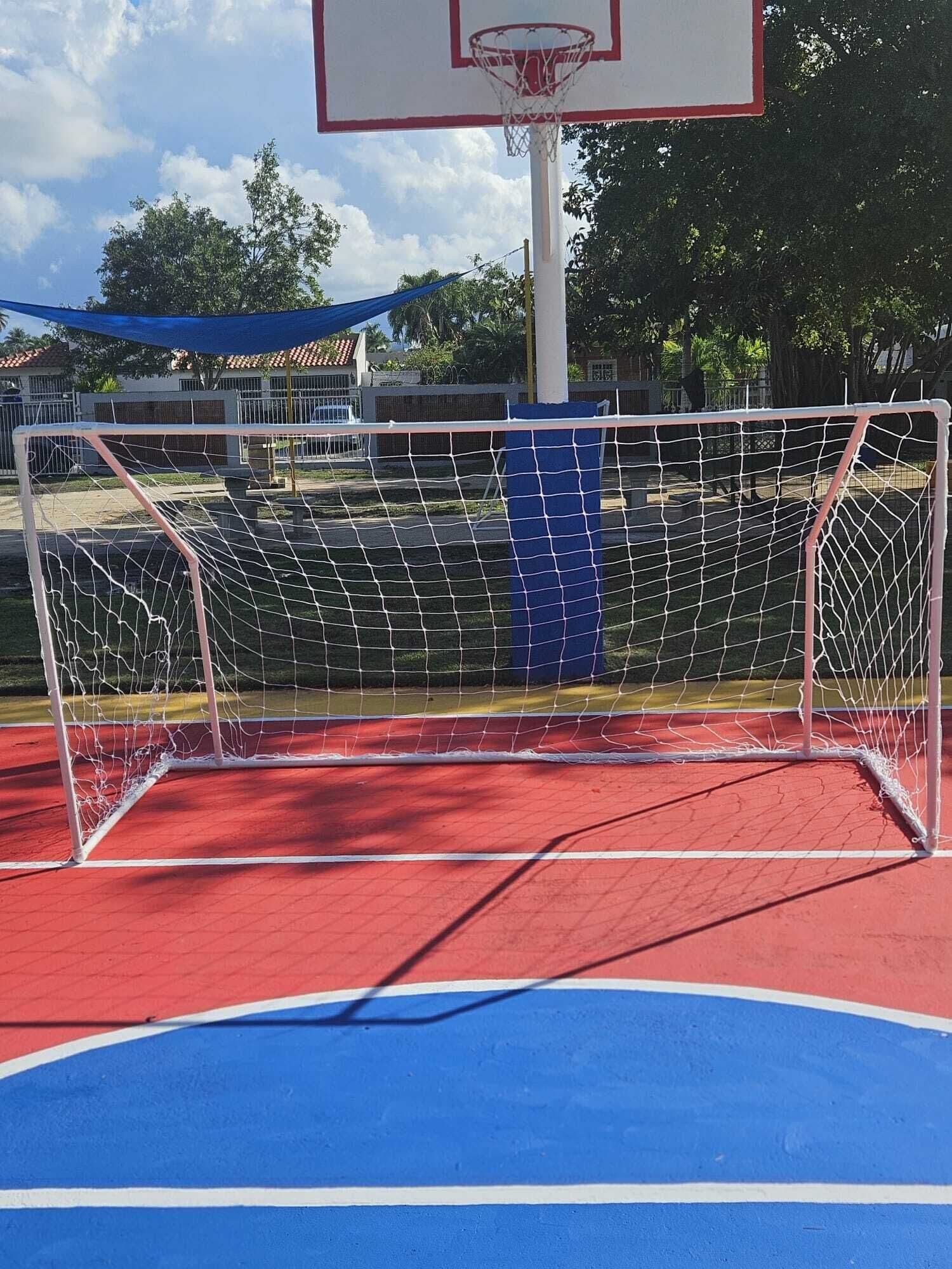 A basketball court with a goal post and a basketball hoop.