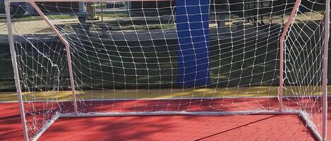 A basketball court with a goal post and a basketball hoop.