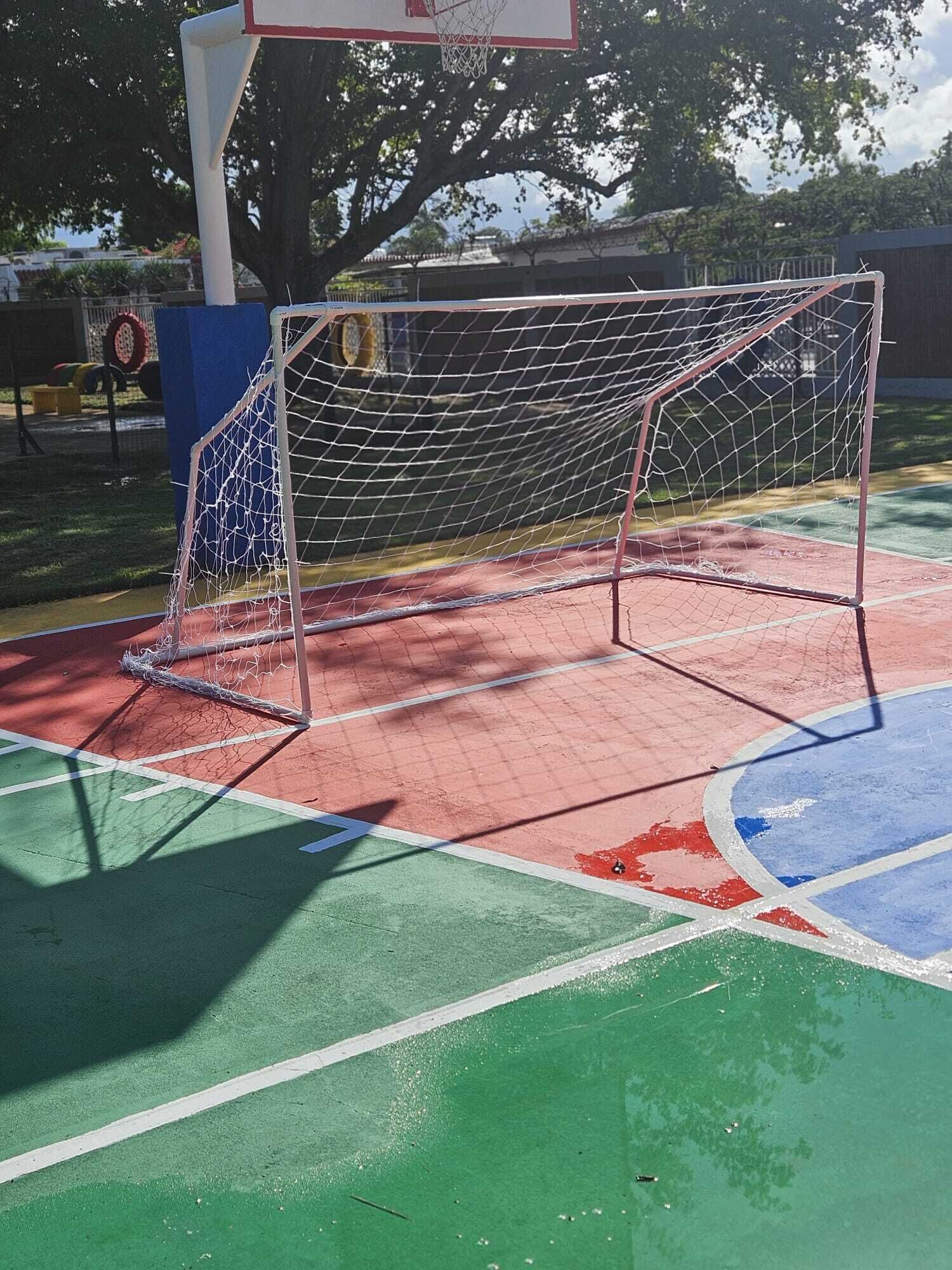 A basketball court with a goal post and a hoop.