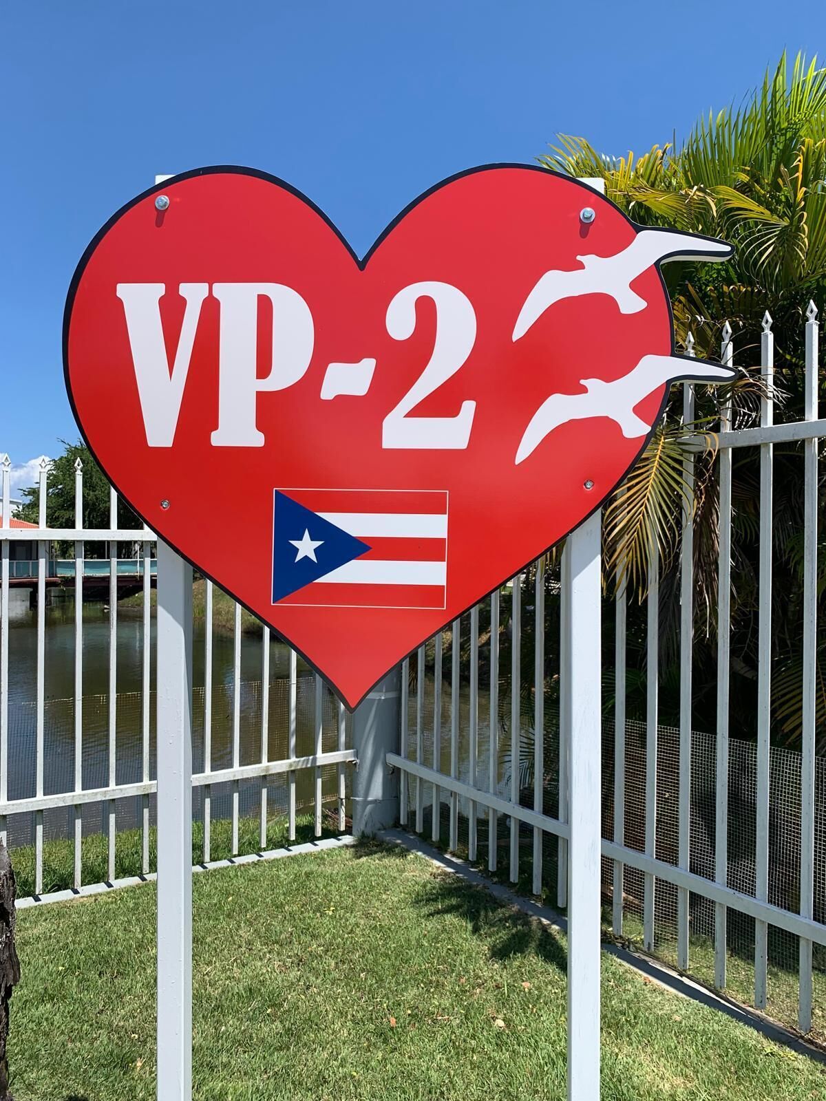 A heart-shaped sign with "VP-2" and a flag, mounted on a pole.