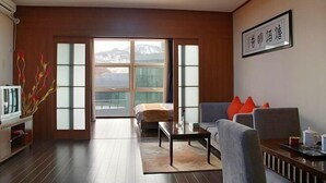 A modern living room with a sofa, coffee table, and a television. - Qingdao Tiantai Meijia Apartment Hotel (Heilongjiang Road Tiantai City Branch) (Qingdao)