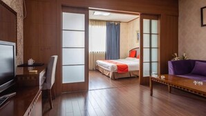 A hotel room with a bed, a TV, a sofa, and a desk. - Qingdao Tiantai Meijia Apartment Hotel (Heilongjiang Road Tiantai City Branch) (Qingdao)