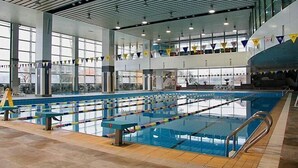 An indoor swimming pool with multiple lanes, large windows, and a high ceiling. - Qingdao Tiantai Meijia Apartment Hotel (Heilongjiang Road Tiantai City Branch) (Qingdao)