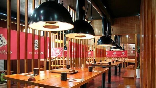 A restaurant with wooden tables and black pendant lights. - Qingdao Tiantai Meijia Apartment Hotel (Heilongjiang Road Tiantai City Branch) (Qingdao)