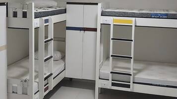 Habitación con literas, un escritorio pequeño y un armario.