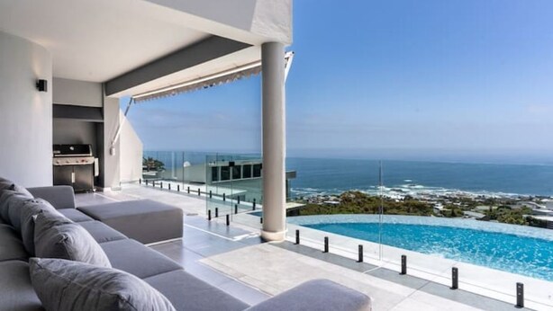 A modern outdoor living area with a pool, overlooking the ocean. - The View CampsBay w/inifinity pool -5 mins from Beach (Cape Town)